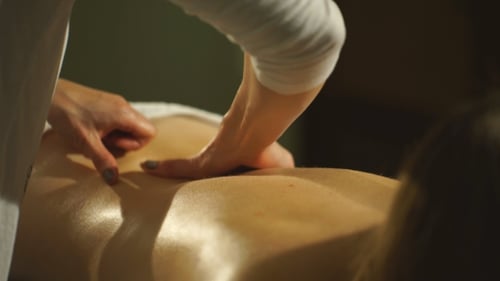 Frau bekommt eine Rückenmassage Hände