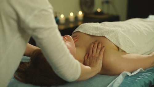 Frau macht eine Schultermassage