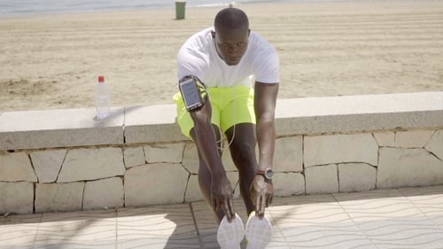Athletic Man Stretching on Beach