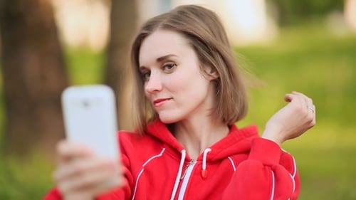 Young Woman Doing Selfie With a White Phone