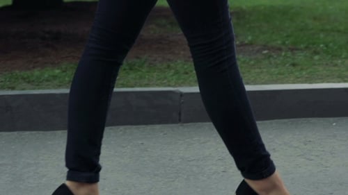 Zapatos negros, piernas de niña, cuerpo caminando por la calle.