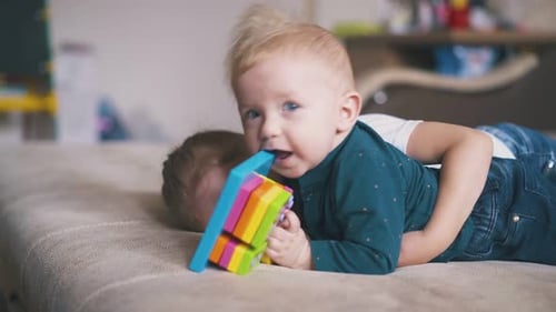 Children Play Together on Couch at Home