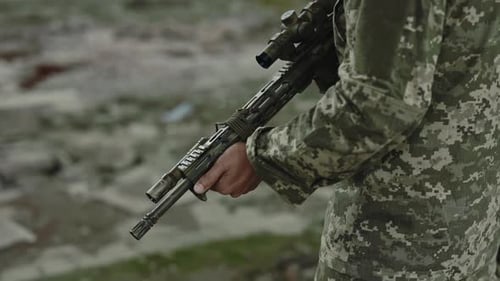 Close Up of Soldier Holding Assault Rifle on Plant