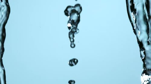 Abstract Streams of Sparkling Water Falling Against Blue