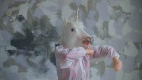Person im Einhorn-Kopfmaske Tanzen in Zeitlupe. Lustige Dancings of Unicorn Mask.
