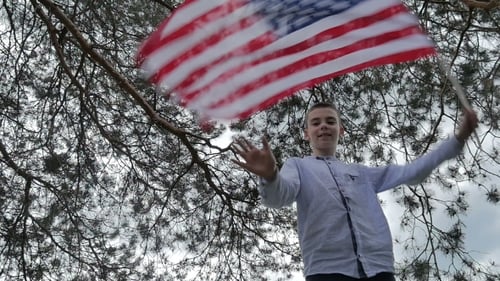 Young Person Waving American Flag Outside