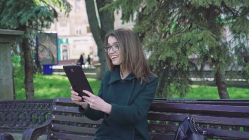Young Woman Using Tablet in Urban Park