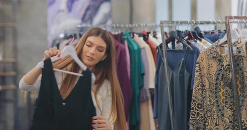 Beautiful Girl Looks Dress in the Store Chooses an Outfit