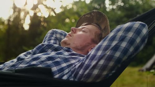 Young Man Relaxing in a Hammock Outdoors