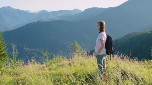 Woman on Top of a Mountain at Sunset