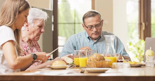 Family Eating Breakfast Together at Wooden Table