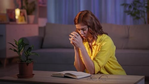 Woman Praying at Table in Quiet Home Setting