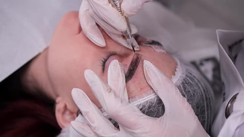 Woman Receiving Cosmetic Eyebrow Tattoo