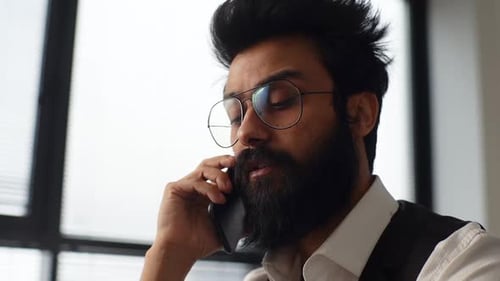 Closeup Lowangle View Face of Serious Young Boss Indian Businessman in Glasses Talking Phone Calling