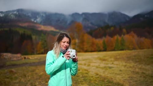 Girl Taking Pictures with a Camera During Autumn