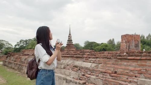 Asian woman using camera for take a picture while spending holiday trip at Ayutthaya.