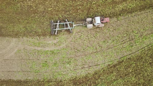 Aerial View of Tractor Plowing Agriculural Farm Field Preparing Soil for Seeding in Summer