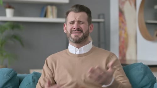 Man Crying and Gesturing in a Modern Home