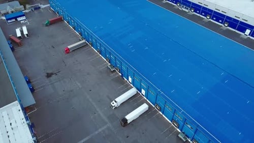 Aerial Top View of the Large Logistics Park with Warehouse with Some Semi-trailers Trucks.