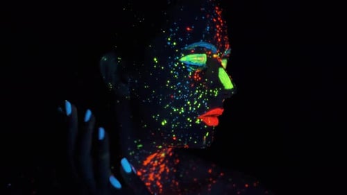 Paint Glowing in Ultraviolet Light. Portrait of a Girl Painted with Glowing Paint