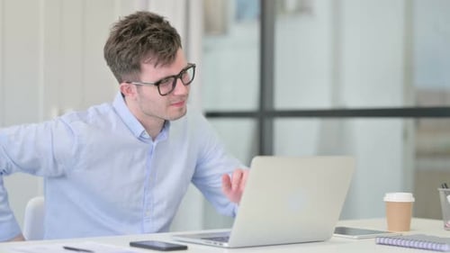 Young Adult Experiencing Back Pain at Workplace