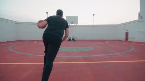 Man Practicing Basketball Skills on Urban Court