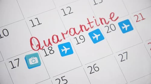 Hand Places Stickers on Monthly Quarantine Calendar