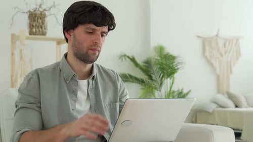 Young Man Receiving Very Bad News on Her Laptop Computer Screen Upset and Frustrated with Failure