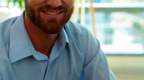 Smiling Man with Beard in Modern Office