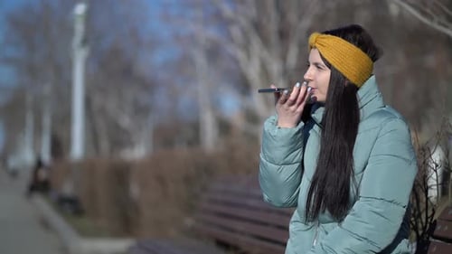 Woman Recording Voice Message in Urban Park