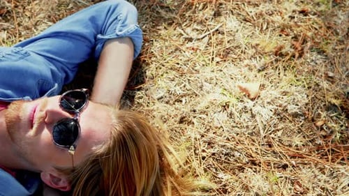 Young Adult Relaxing in Grass on Sunny Day