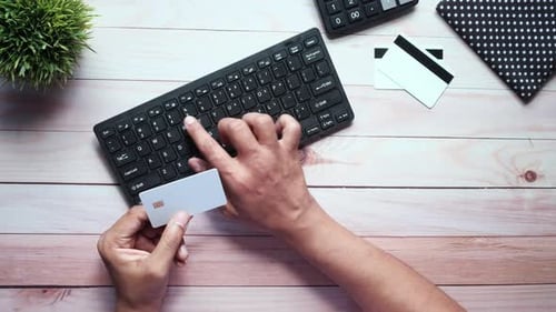 Mann hält die Kreditkarte in der Hand und tippt den Sicherheitscode auf der Tastatur ein.
