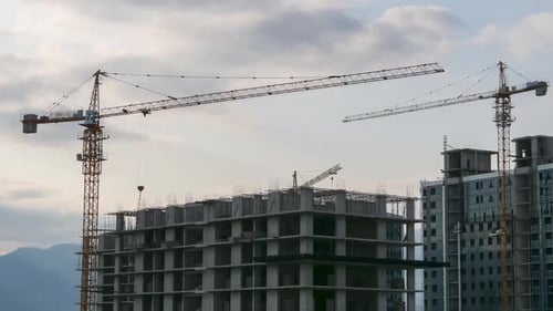 Tower Crane on a Construction Site Lifts a Load at High-rise Building. Timelapse. Building
