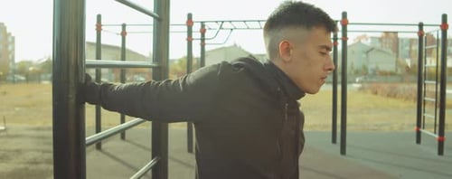 Sporty Man Stretching Shoulders on Workout Playground