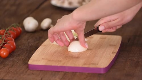 Close Up Hands Dicing White Onion on Wood Block