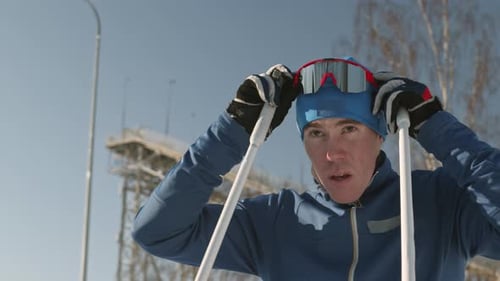 Male Skier Putting on Goggles