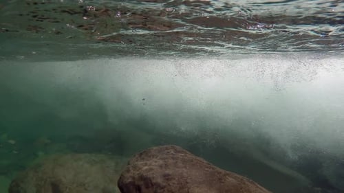 Unterwasserfelsen und Luftblasen am Stream