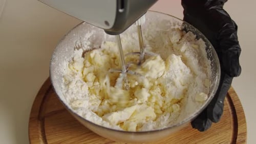 Cose Up View Baker Zutaten in Schüssel mischen Teig backen Kuchen mit elektrischem Mixer Top