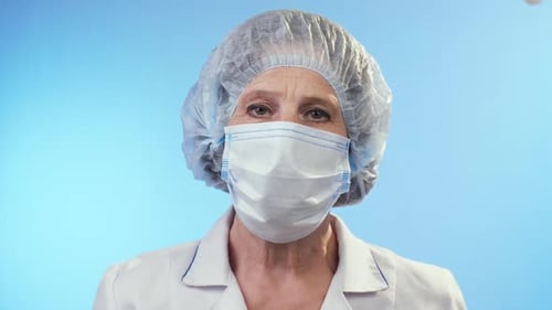 Senior Doctor Wearing Surgical Mask and Bouffant Cap