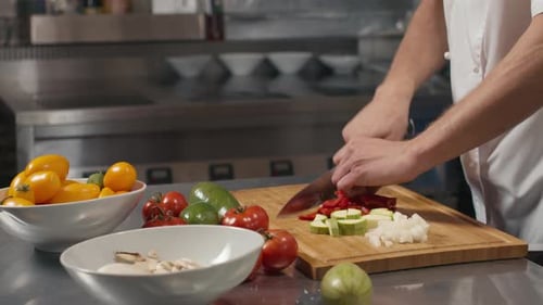 Chef Dices Fresh Vegetables on Cutting Board
