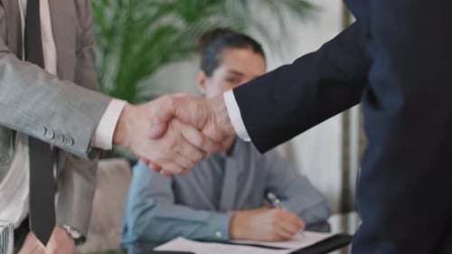Business Handshake After Signing Agreement in Office