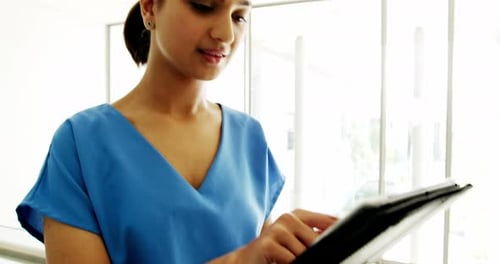 Beautiful surgeon using digital tablet in the ward