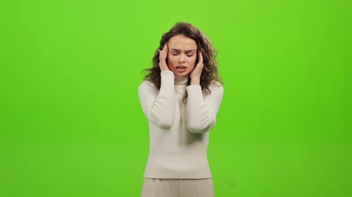 Young Woman Massaging Temples on Green Screen