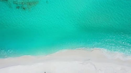 Daytime aerial tourism shot of a sunshine white sandy paradise beach and turquoise sea background in