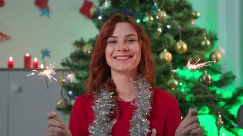 Smiling Woman Celebrates Christmas with Sparklers