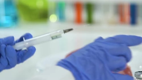 Gloved Hand Injecting Meat Sample in Laboratory
