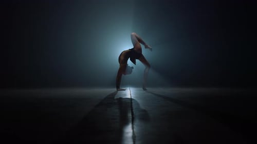 Gimnasta flexible haciendo ejercicios de flexión hacia atrás