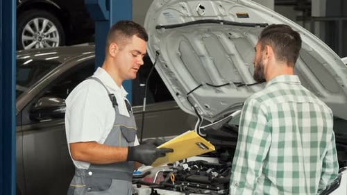 Car Mechanic Talking To the Client at Automotive Service Center