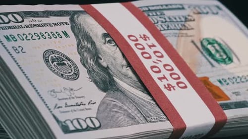 Bundles of Dollars Rotate on Black Background