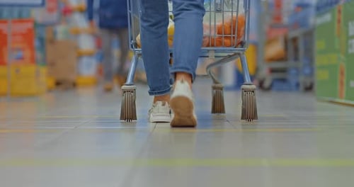 Closeup Female Legs in Sneakers Walking Through the Supermarket
